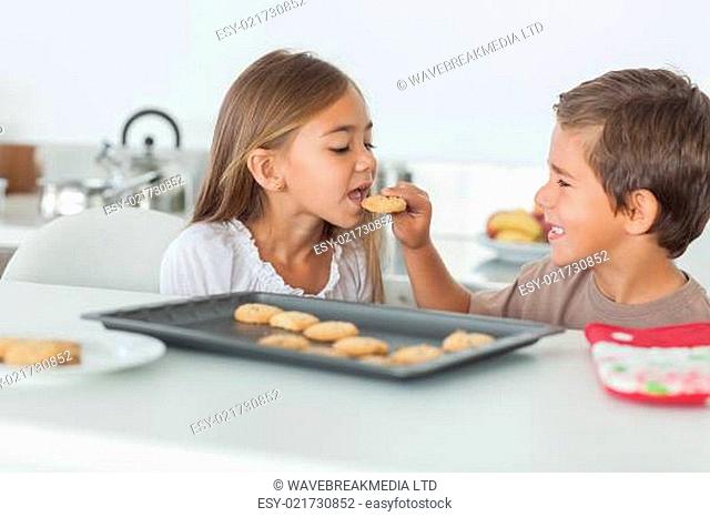 Brother giving a cookie to his sister