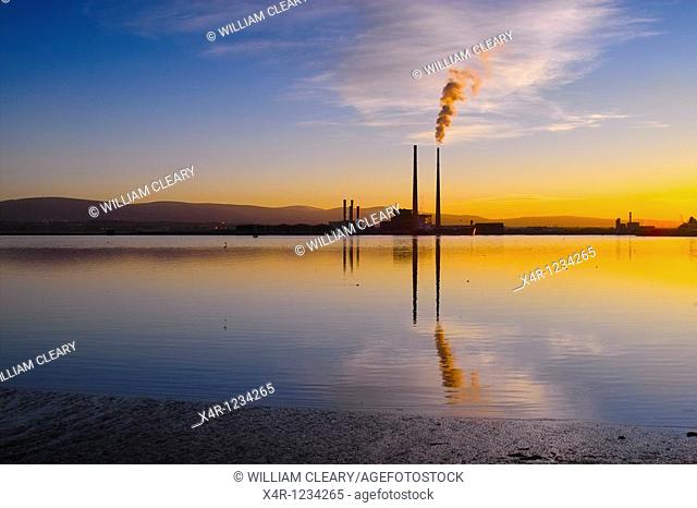 Sunset over Dublin Bay, Ireland. To the right is the iconic Poolbeg Power Station, with smoke billowing from its right cooling tower
