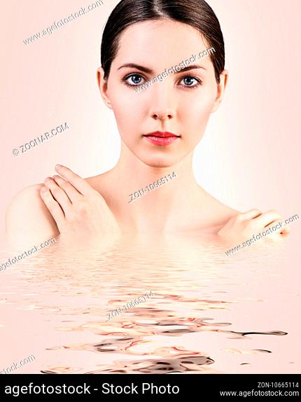 Young beautiful woman with reflection on water surface