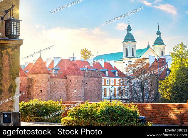 Warsaw Barbican and ancient church at sunset in autumn, Poland