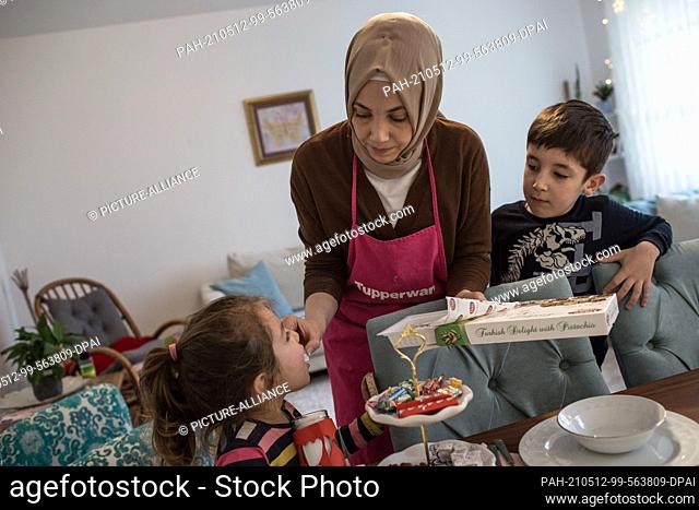 PRODUCTION - 10 May 2021, North Rhine-Westphalia, Minden: Hatice Bahadir gives her children sweets. During the day, believers in Ramadan do not eat anything;...