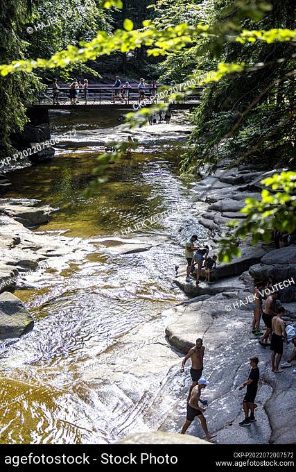 People enjoy cool water swimming in Mumlava River Waterfall, Giant Mountains, Liberec Region, Czech Republic, on Wednesday, July 20, 2022