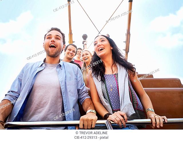 Enthusiastic couple riding amusement park ride