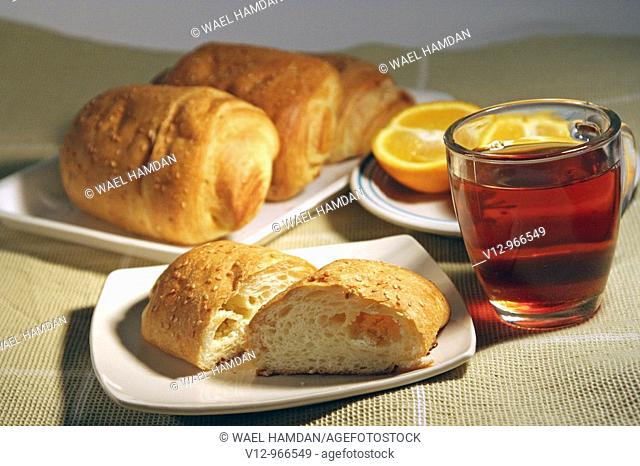 Pastries with tea and orange fruit