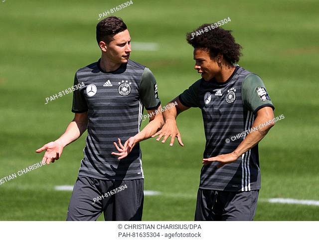 Germany's Julian Draxler (L) talks to Leroy Sane during a training session of the German national soccer team on the training pitch next to team hotel in Evian