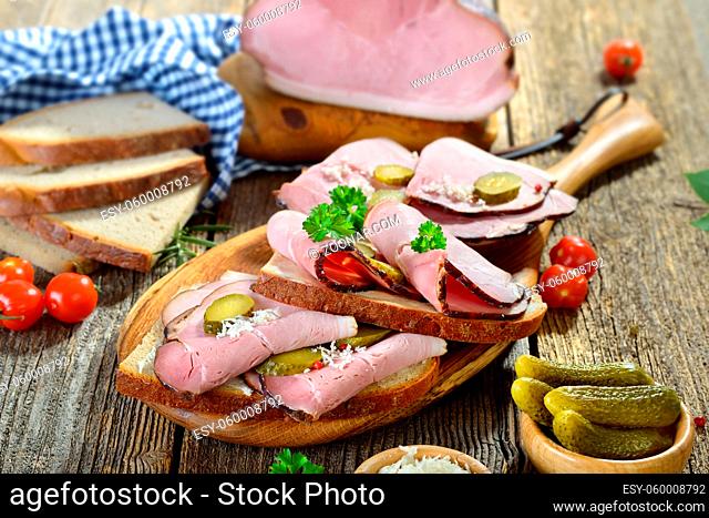 Brotzeit mit deftigem schwarzgeräucherten Landschinken und frischem Meerrettich auf Bauernbrot ? Bavarian snack with smoked country ham with freshly grated...