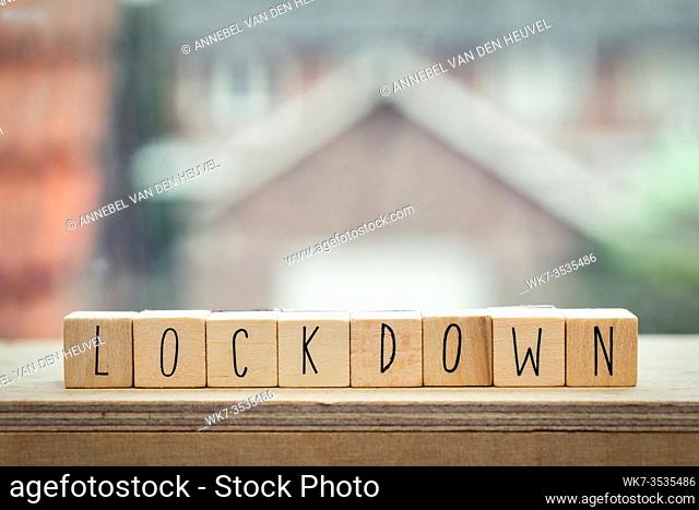 Wooden cubes with the word Lockdown for coronavirus, Covid-19 near a window, stay home concept worldwide virus