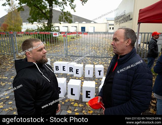 02 November 2023, Saxony-Anhalt, Eisleben: Works council members Florian Wieland (l) and Armin Söhl talk in front of the factory gate of the toy and furniture...