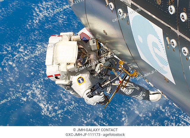 Astronaut Randy Bresnik (near the Columbus laboratory), STS-129 mission specialist, participates in the mission's second session of extravehicular activity...