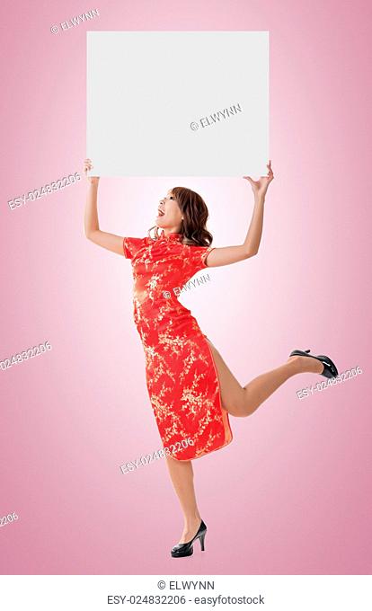 Attractive Chinese woman dress traditional cheongsam and hold blank board, full length portrait