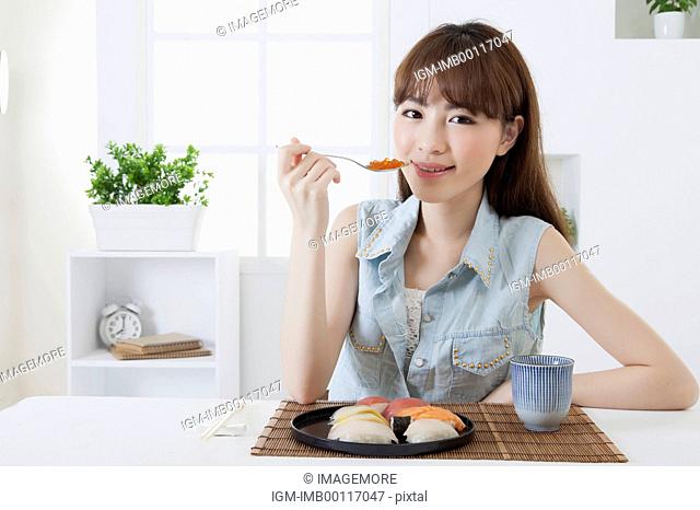Young woman holding Japanese food and smiling at the camera