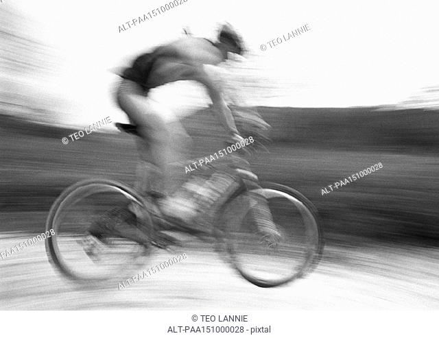Man cycling, side view, blurred, b&w
