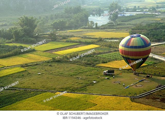 Preparing to launch a hot-air balloon from the first Chinese hot air balloon club in the middle of rice and grain fields in Yangshuo on the Yulong River, Guilin