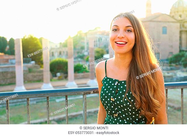 Beautiful young tourist girl visiting the Roman Forum in Rome, Italy at sunset