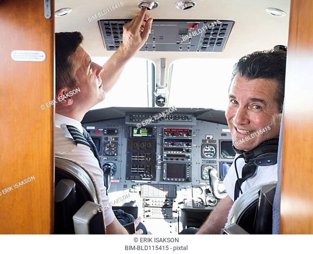 Caucasian pilots in airplane cockpit