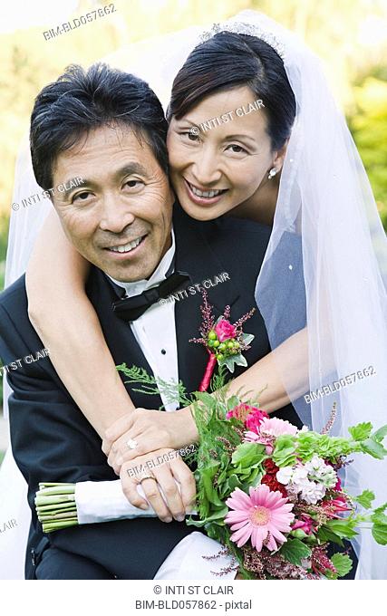Asian newlyweds hugging
