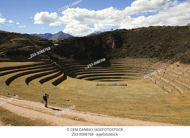 Tourist walking on the terraces at Moray Ruins of the ancient Inca empire, Cusco Region, Peru, South America