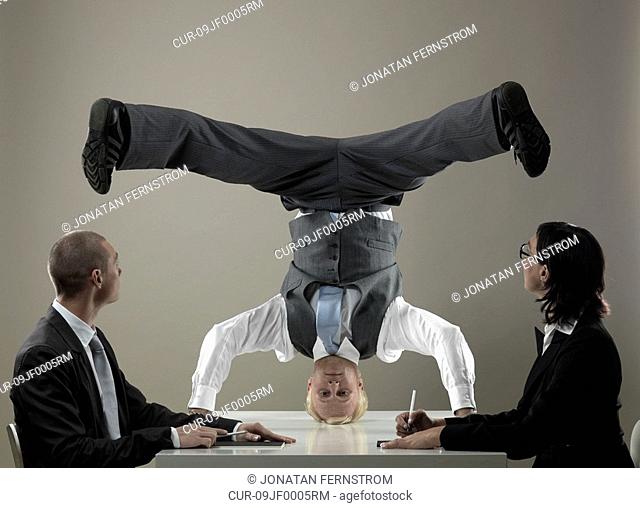 Business man standing on head