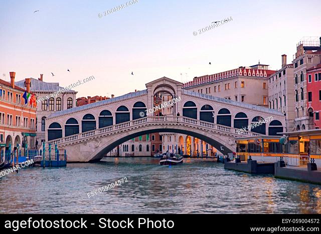 Rialto Bridge (Ponte de Rialto) across Grand Canal at sunrise / sunset time, Venice, Italy