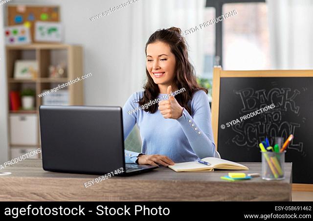 teacher with laptop having online class at home
