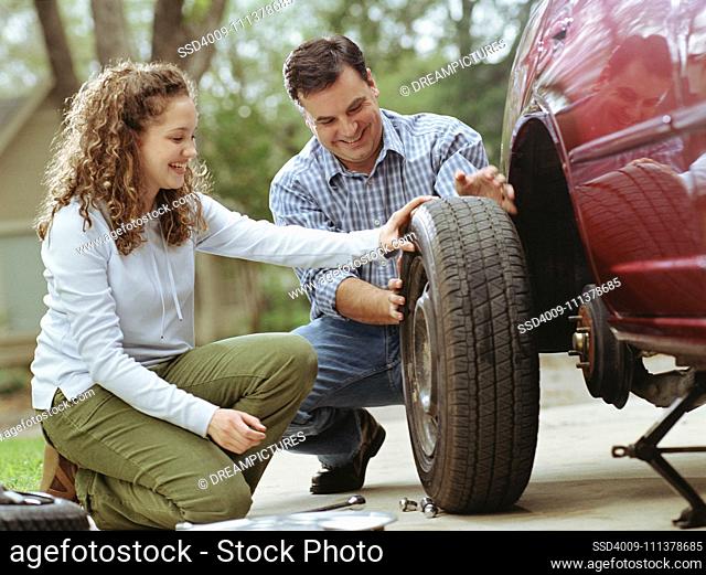 Couple changing a car's tire together