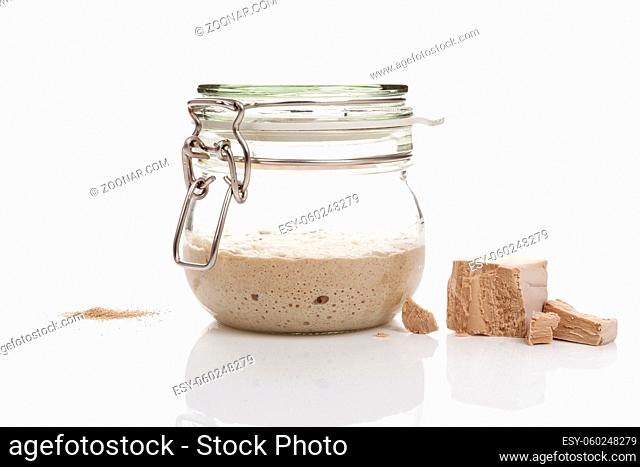 Yeast types isolated on white background. Fresh pressed, dry instant, and sourdough starter in glass jar