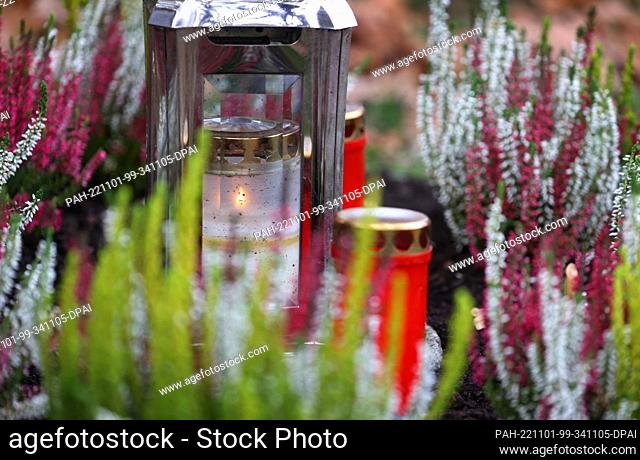 01 November 2022, Bavaria, Kempten: Candles burn on a grave at the Central Cemetery on All Saints' Day. Photo: Karl-Josef Hildenbrand/dpa