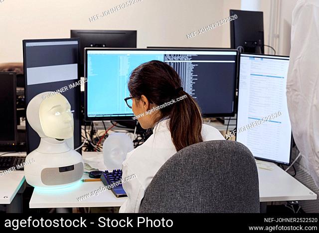 Female engineer working on robot