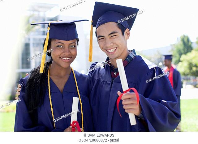 Graduates with diplomas smiling together