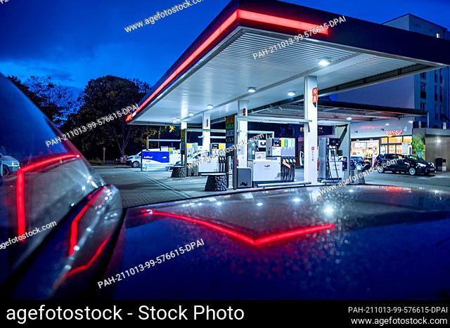 PRODUCTION - 11 October 2021, Berlin: Reflection of a petrol station of the mineral oil company Total in Chausseestraße. Federal Statistical Office announces...