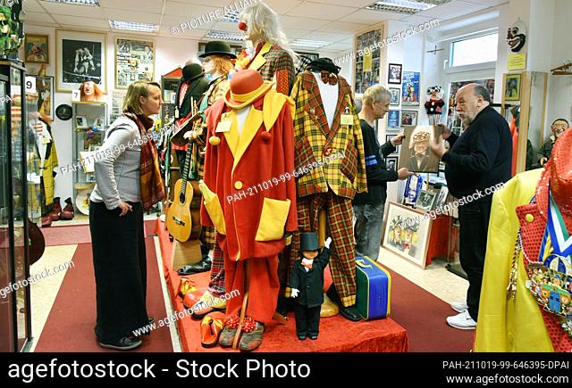 06 October 2021, Saxony, Leipzig: Collector Hans-Dieter Hormann (r) shows visitors around his unique clown museum. The native Rhinelander and trained civil...