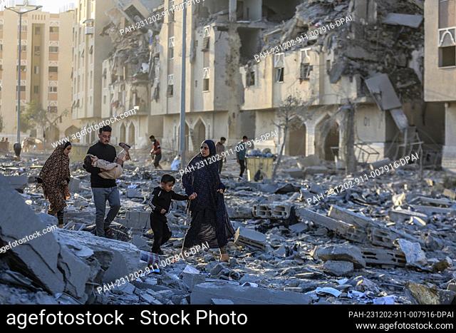 02 December 2023, Palestinian Territories, Khan Yunis: Residents of the Qatari-funded Hamad Town residential complex in Khan Yunis in the southern Gaza Strip...