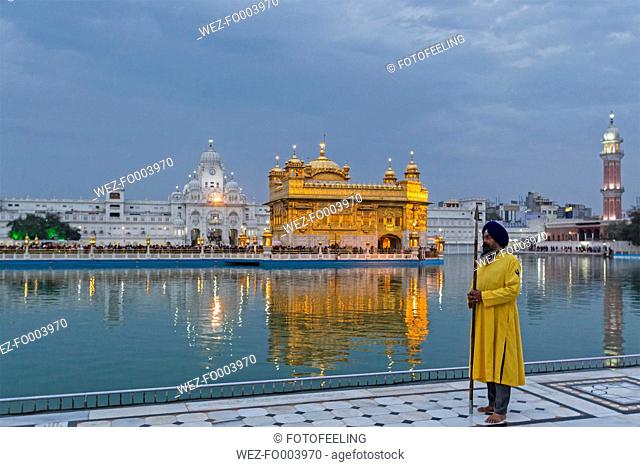 India, Punjab, Amritsar, Portrait of Sikh guard holding spear at Golden Temple