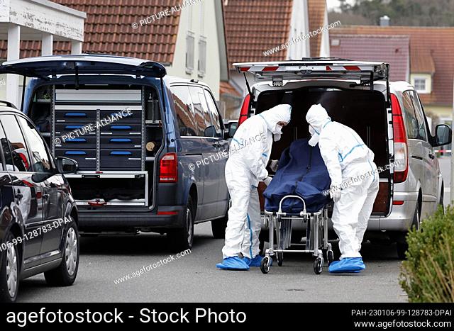 06 January 2023, Bavaria, Weisendorf: Employees of the forensics department load the body of a teenager into a vehicle. A violent crime rocked the town of...
