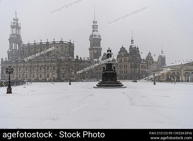 23 January 2021, Saxony, Dresden: It snows in the morning on the Theaterplatz with the Hofkirche (l-r), the Hausmannsturm, the equestrian statue of King Johann