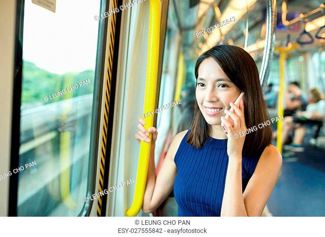 Woman talk to cellphone inside train compartment