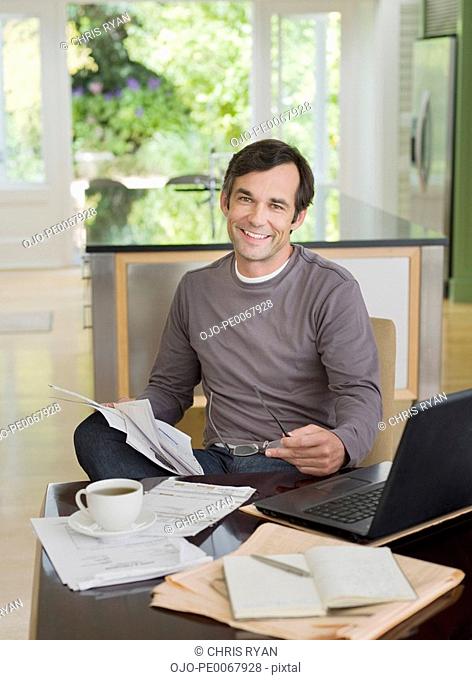 Man paying bills near laptop