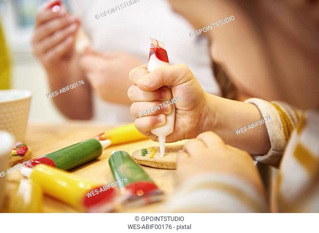 Close-up of sisters decorating Easter cookies
