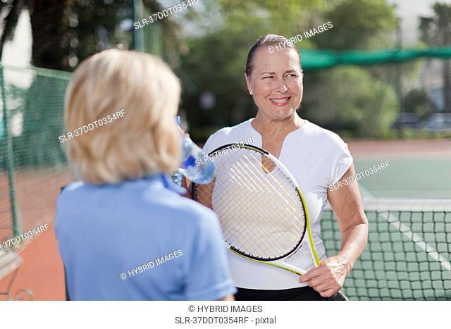 Older women talking on tennis court