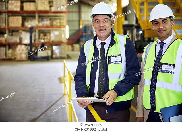 Portrait confident manager and worker in distribution warehouse