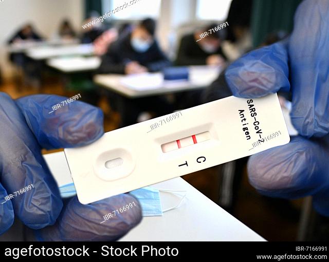 PHOTOMONTAGE, positive antigen rapid test, mouth mask on student desk, face-to-face teaching, Corona crisis, Stuttgart, Baden-Württemberg, Germany, Europe