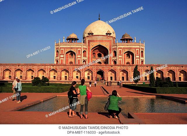 Tourists at Humayun's tomb built in 1570 made from red sandstone and white marble first garden-tomb on Indian subcontinent persian influence in mughal...