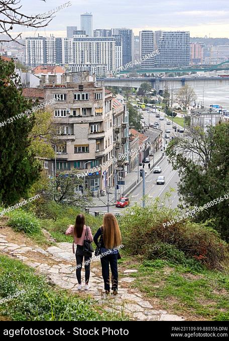 07 November 2023, Serbia, Belgrad: Two women look out over the Serbian capital from a hill. In the background are the new buildings of the ""Belgrade...