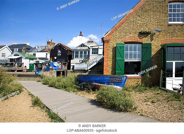 England, Kent, Whitstable, A boardwalk leading past the Whitstable Oyster Company restaurant and beach front properties in Whitstable