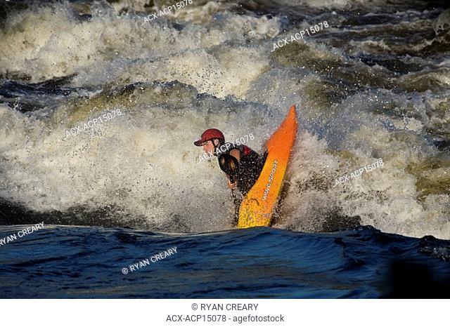 A kayaker playboating in the Ottawa River, Ontario, Canada