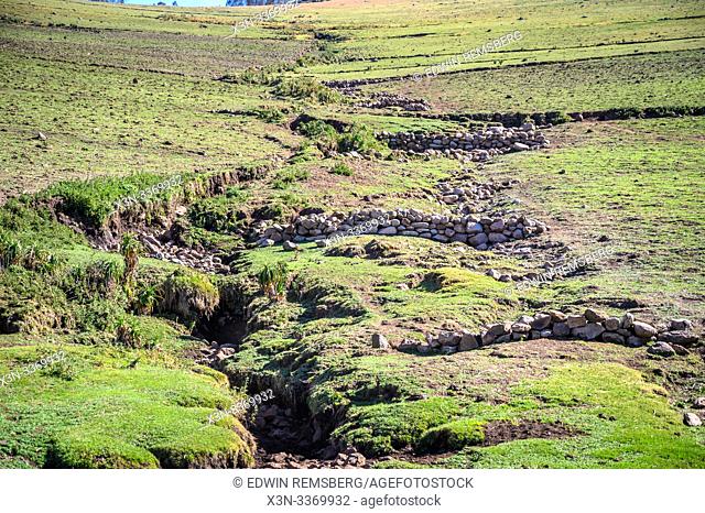 Stone walls are layered down a rugged hillside, Ankober, Ethiopia