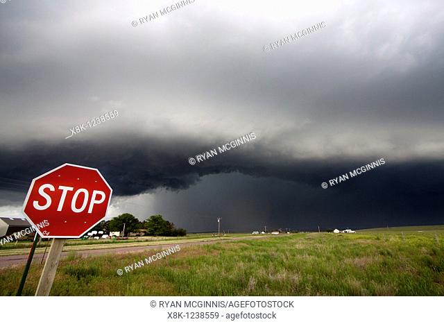 A stopsign marks an intersection with a large, soon to be tornadic supercellular thunderstorm in the background near Scottsbluff, Nebraska, June 7, 2010