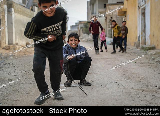 02 January 2021, Syria, Afes: Syrian children play on the street amongst damaged buildings at the village of Afes. Residents of Afes started returning back to...