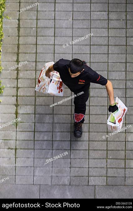Stockholm, Sweden A delivery man from the ICA supermaket chain delivers packages of groceries in a residential neighborhood