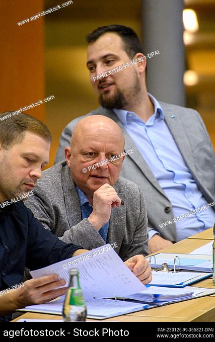 26 January 2023, Saxony-Anhalt, Magdeburg: Hagen Kohl (M, AfD) sits in the plenary chamber of the Saxony-Anhalt state parliament between MPs Jan Moldenhauer (l)...